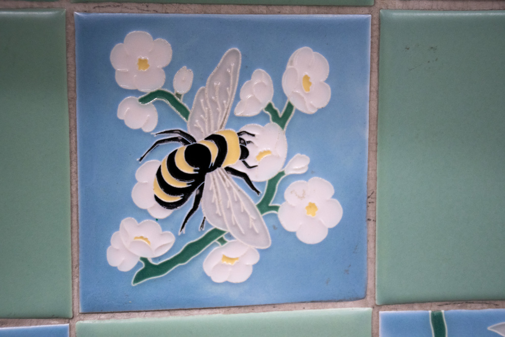 decorative tile depicting a bumble bee on a flower