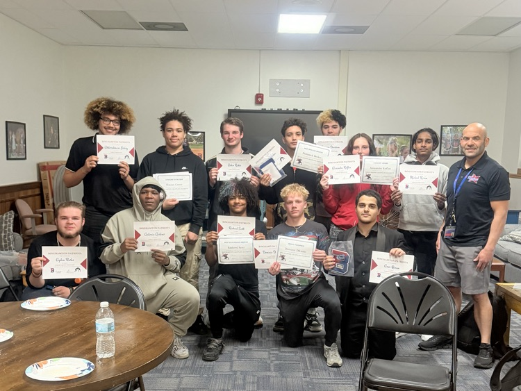 Binghamton wrestlers posing for photo holding awards