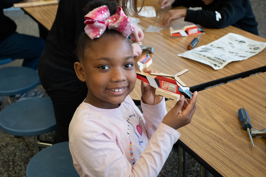 student shows off model wooden helicopter