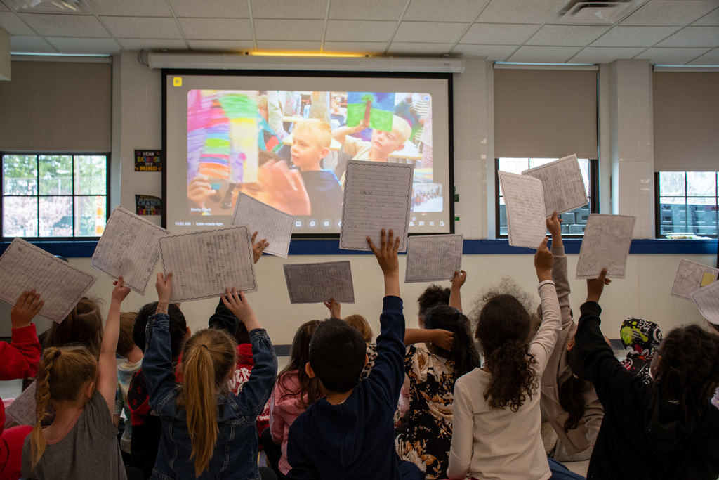 thomas jefferson students hold up letters from their wyoming pen pals while they video chat with them