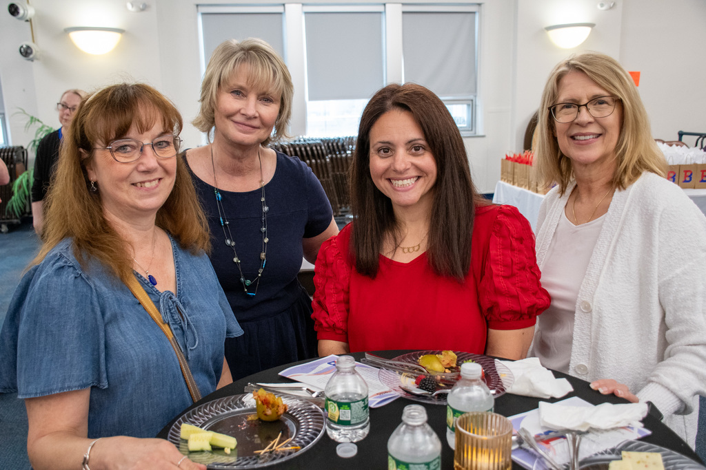 four staff members smile for photo