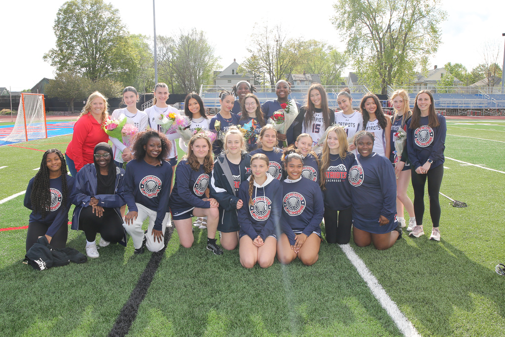 girls varsity lacrosse players pose for photo on field