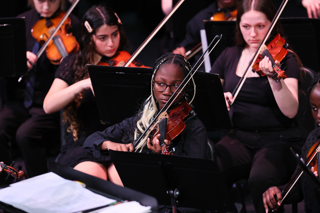 bhs orchestra students play violins on stage at helen foley theatre