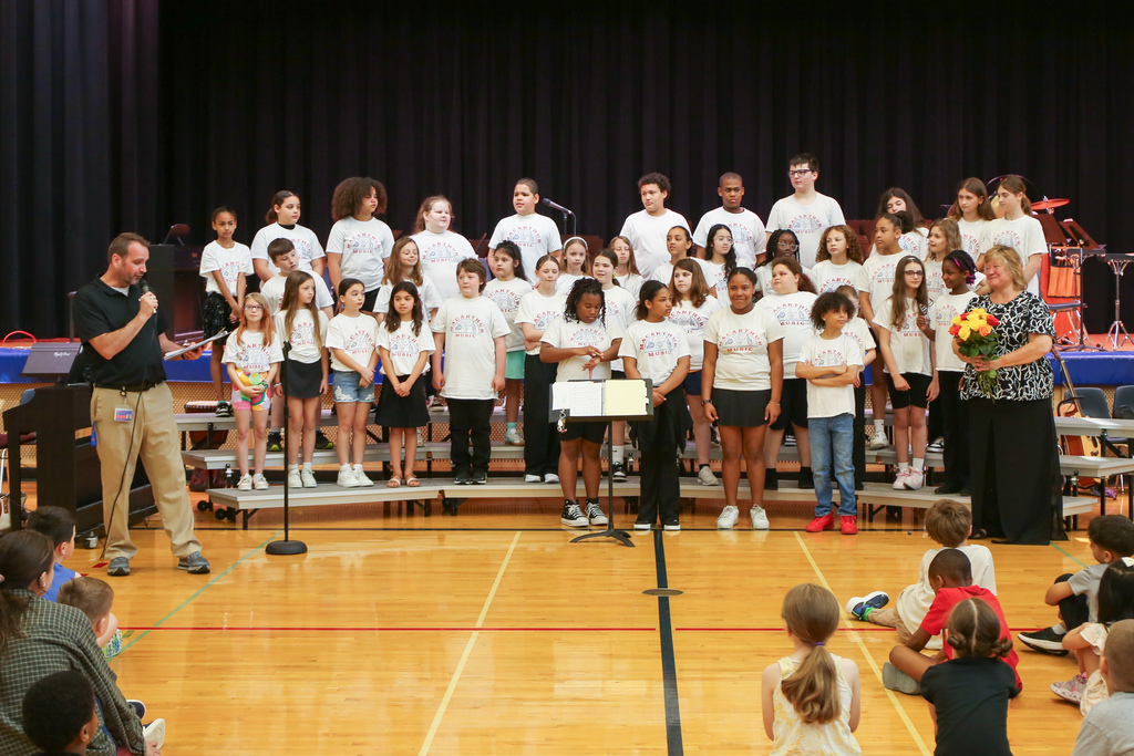 music teacher wendi stetson stands with students as principal recognizes her retirement