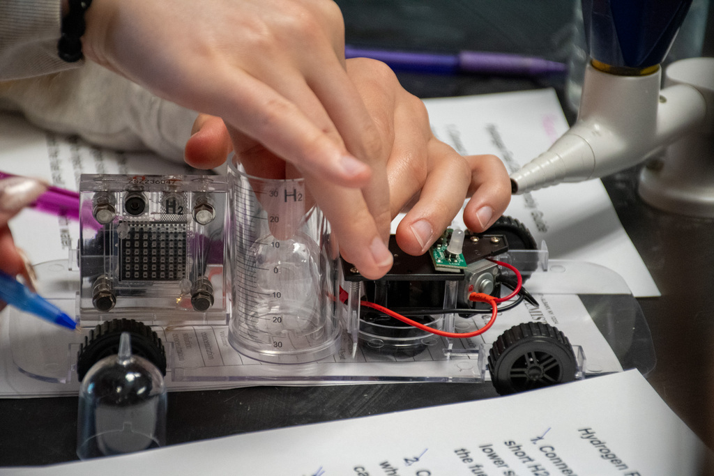close up of student's hands building hydrogen fuel cell car