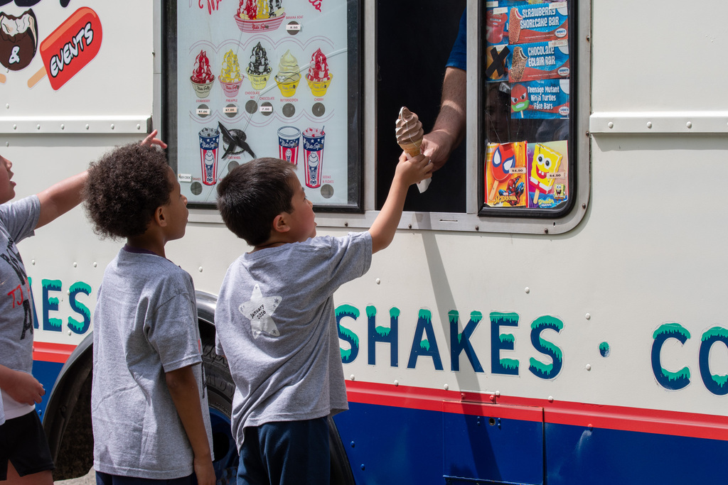 student is handed ice cream cone from ice cream truck