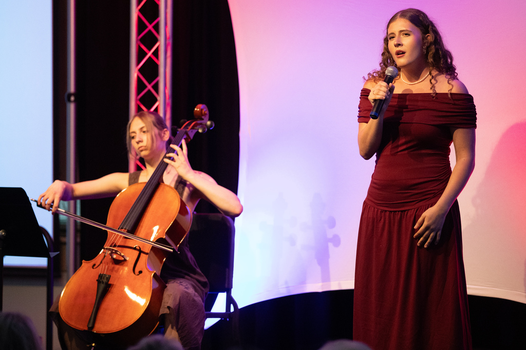 student sings while second student plays cello
