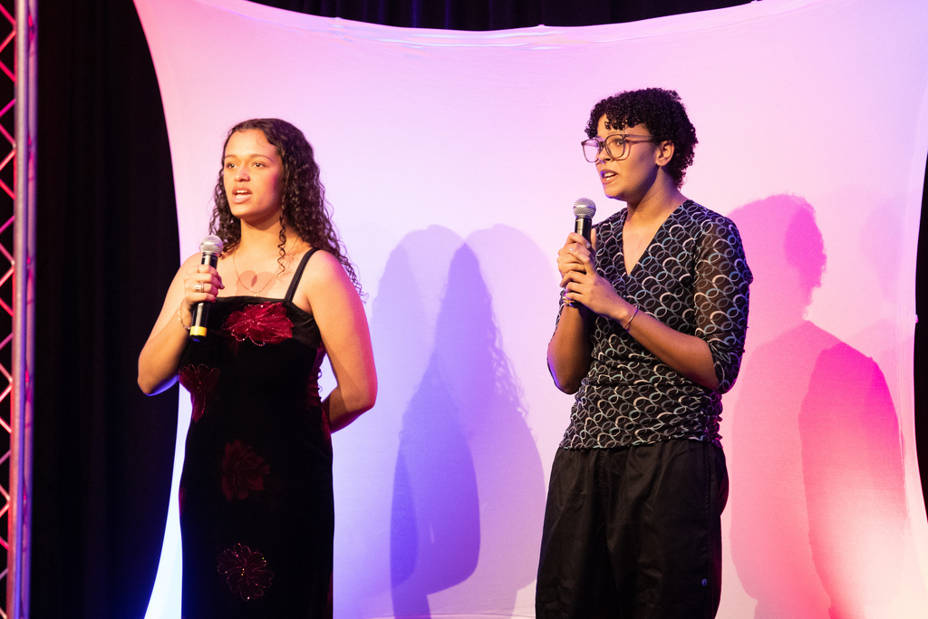 two students singing on stage