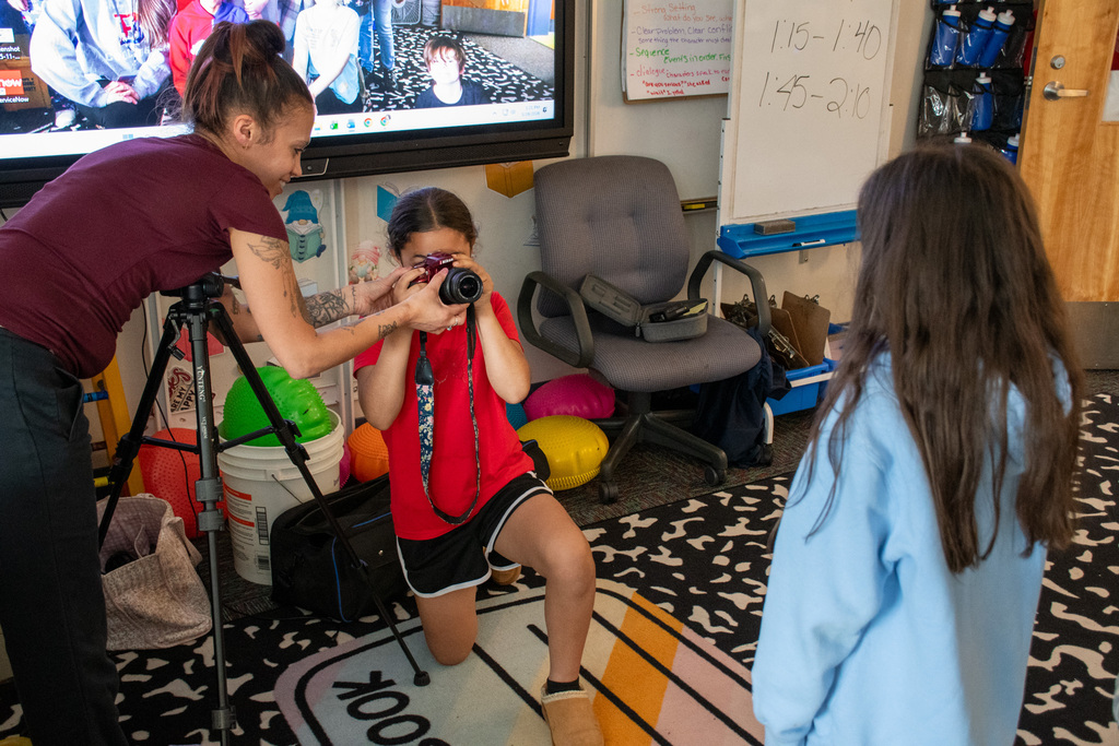 photographer helps student use camera