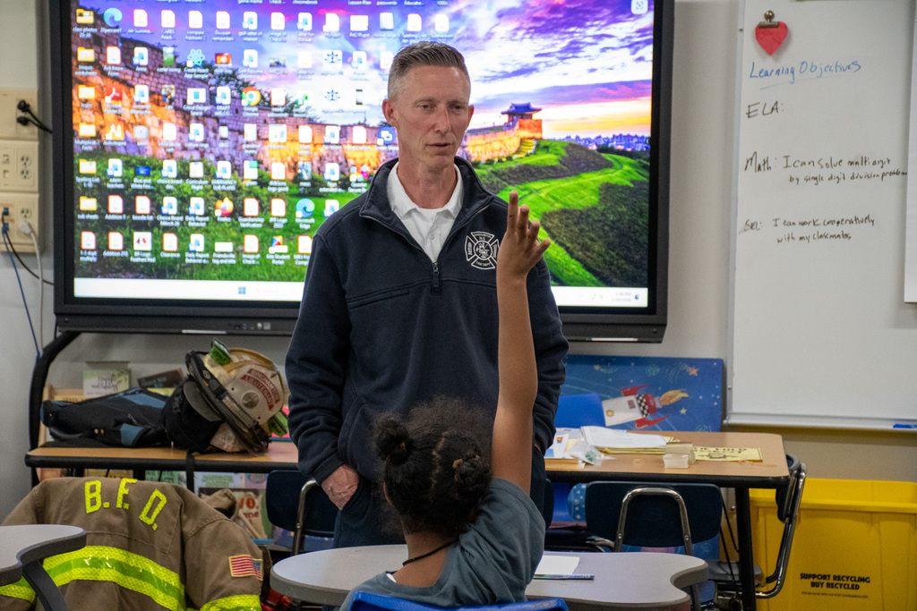 student raises hand to ask fire fighter a question