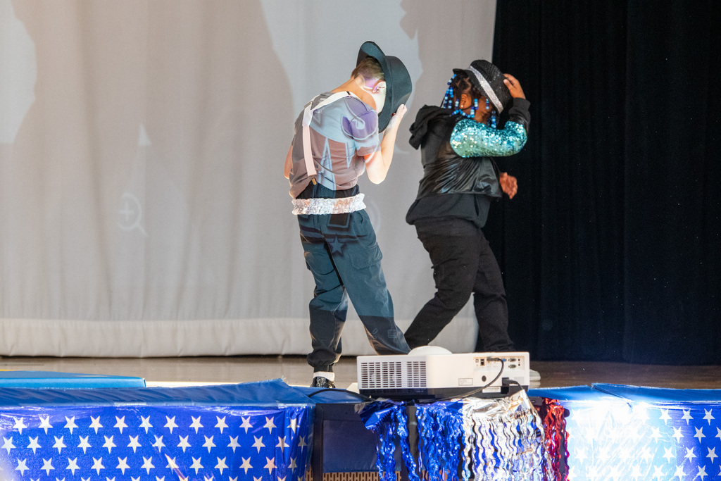 two macarthur students dance while wearing fedoras