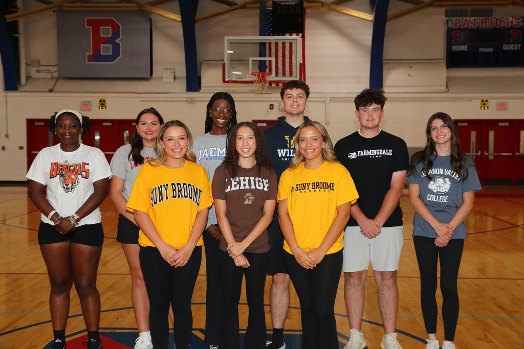 nine binghamton student-athletes pose for photo after signing letters of intent to play college sports