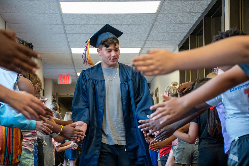 bhs senior gives high fives to students at theodore roosevelt