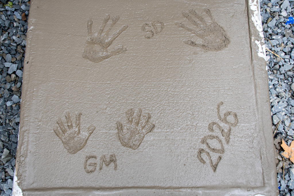 samantha dalmolen's and gio marcello's handprints in concrete with their initials and date