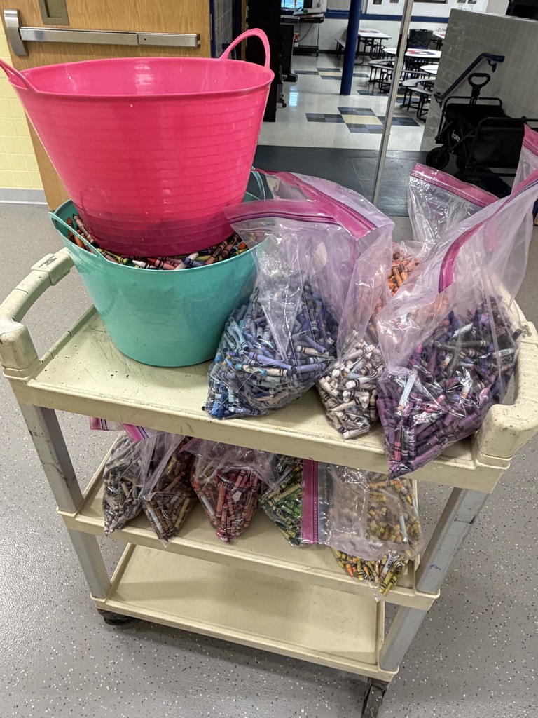 bags and bins of used crayons sit on cart 