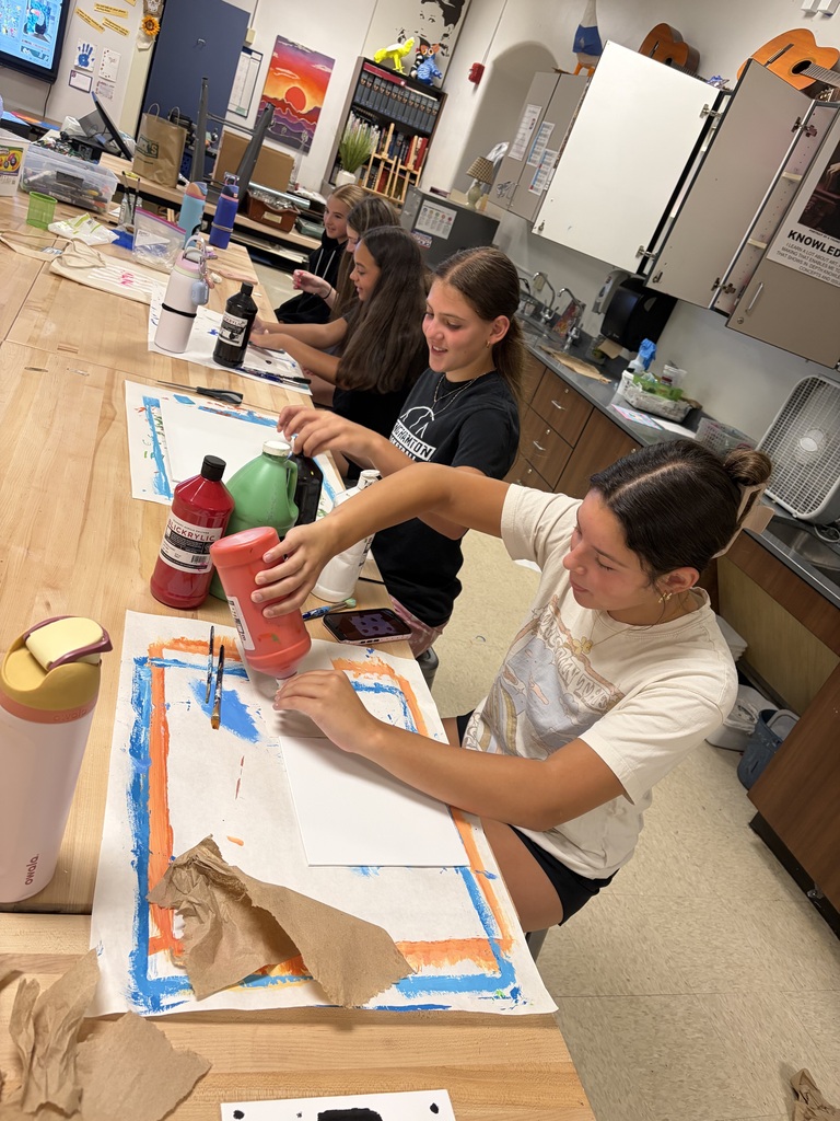 student squirts paint onto canvas at mixed media camp at BHS