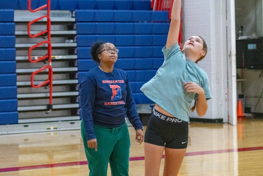 coach watches girl shoot layup