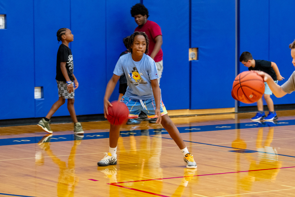 student dribbles basketball