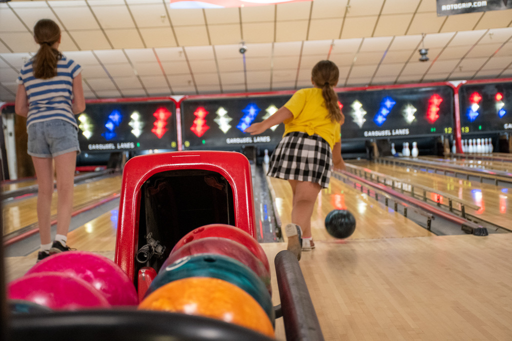 two students throw bowling balls at patriots bowling camp