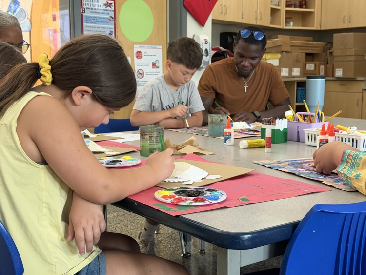teacher and student work on sea turtle craft