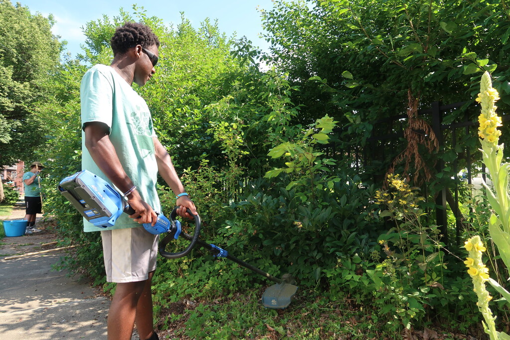 student uses weed whacker