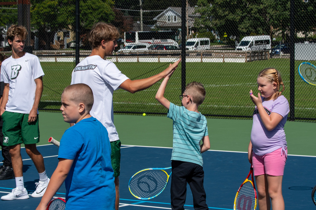 binghamton university men's tennis player high fives horace mann student