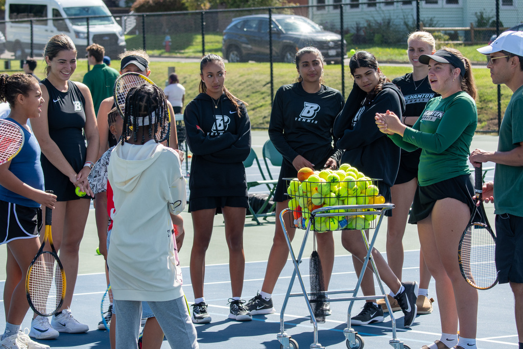 binghamton university women's tennis player talks to group of horace mann students on tennis court