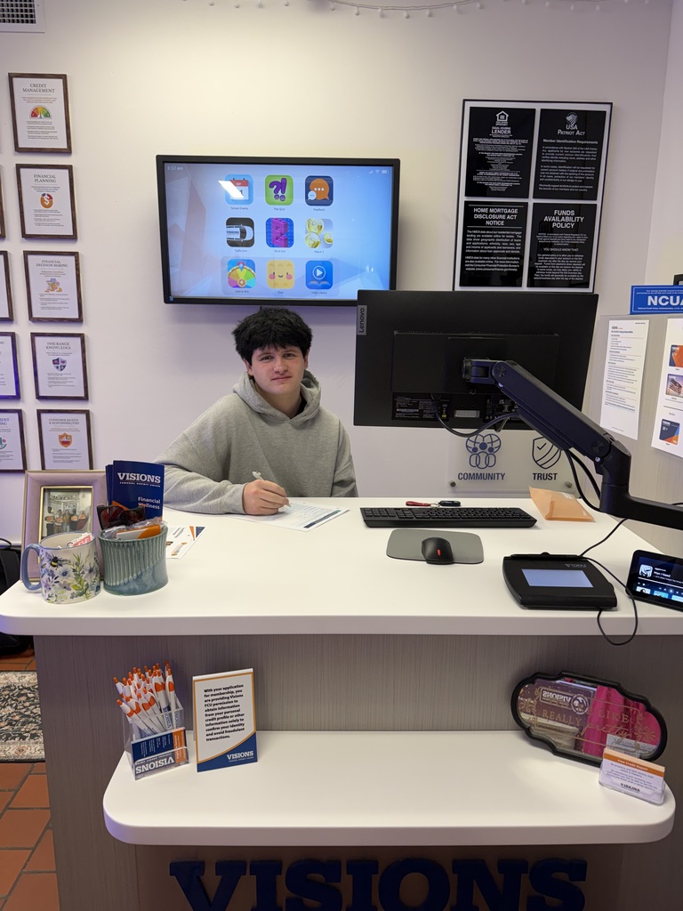 visions intern brenden sitting at teller's desk