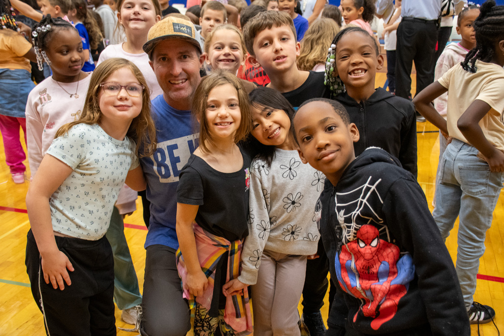 students pose with assembly guest speaker at macarthur elementary