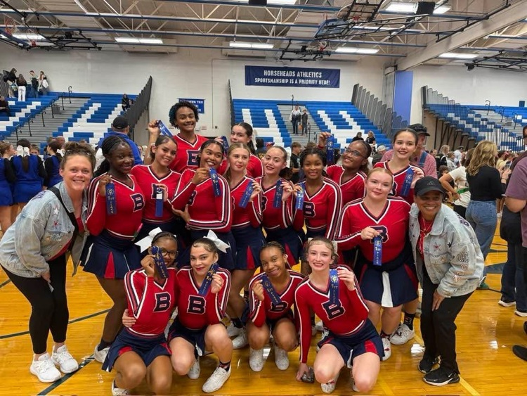 BHS varsity cheer team poses for photo holding first place ribbons