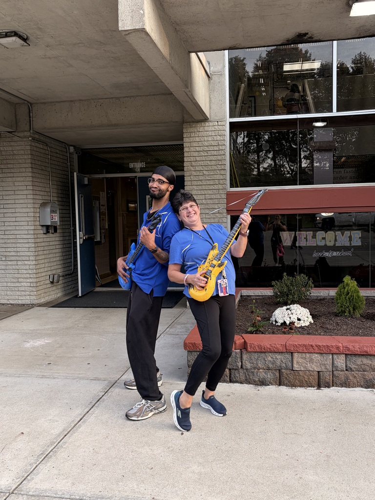 horace mann staff members pretend to play inflatable guitars outside of school