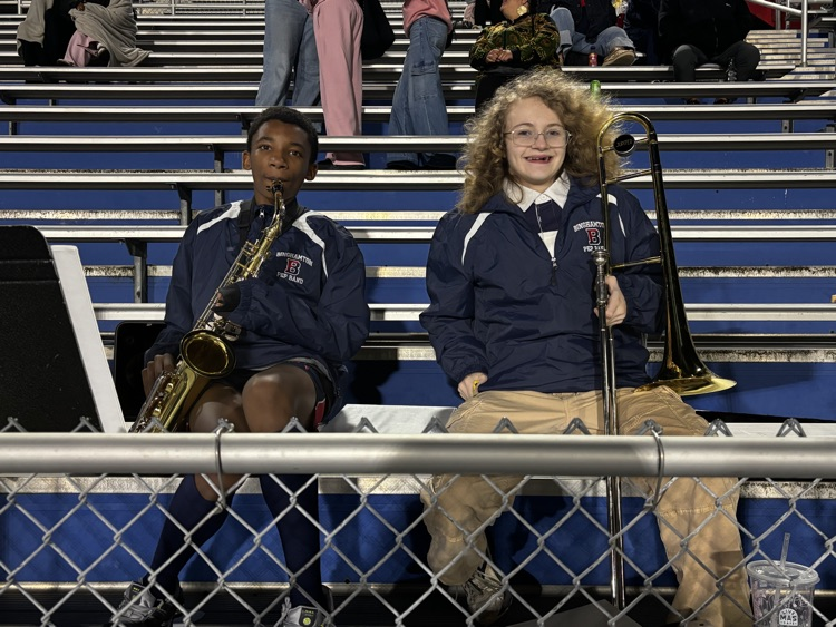 students holding saxophone and trombone