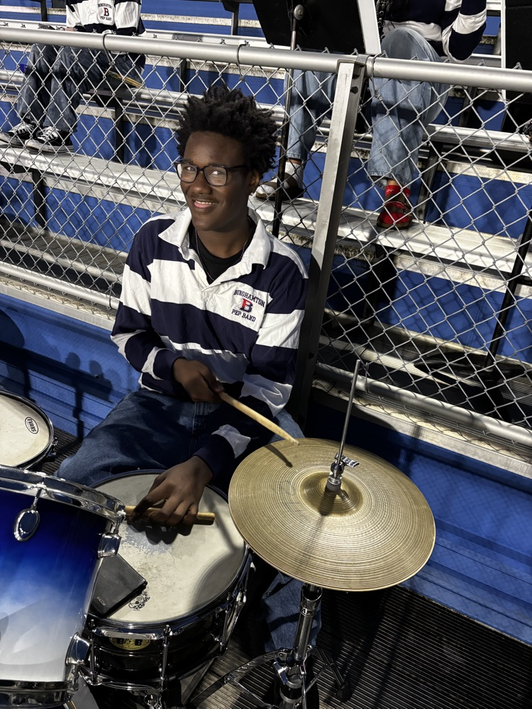 student sitting at drum kit