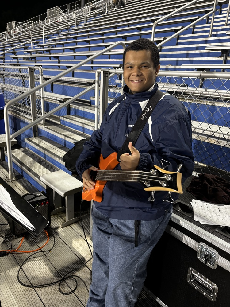 student holding bass guitar