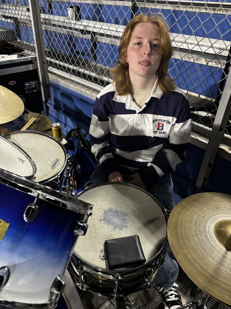 student sitting at drum kit