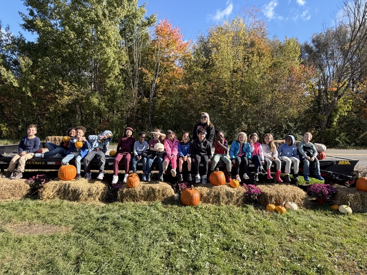 Woodrow Wilson students sit on truck flat bed with bales of hay and pumpkins in front of them
