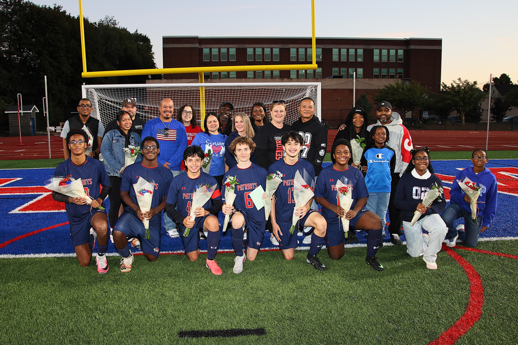 seniors from the boys soccer team pose for photo with their families
