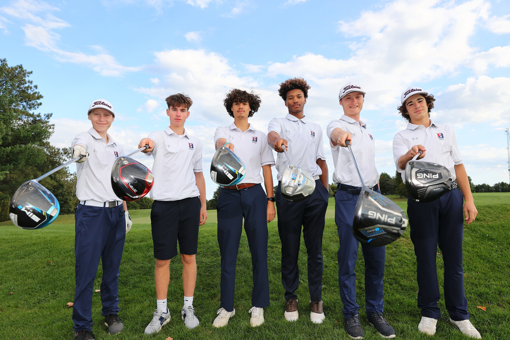 seniors from the bhs golf team standing while holding drivers extended towards the camera