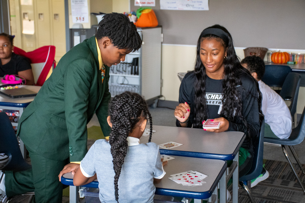 binghamton university women's basketball player plays cards with macarthur student