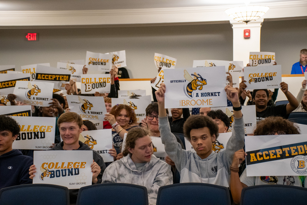 BHS students hold up posters inside helen foley theatre