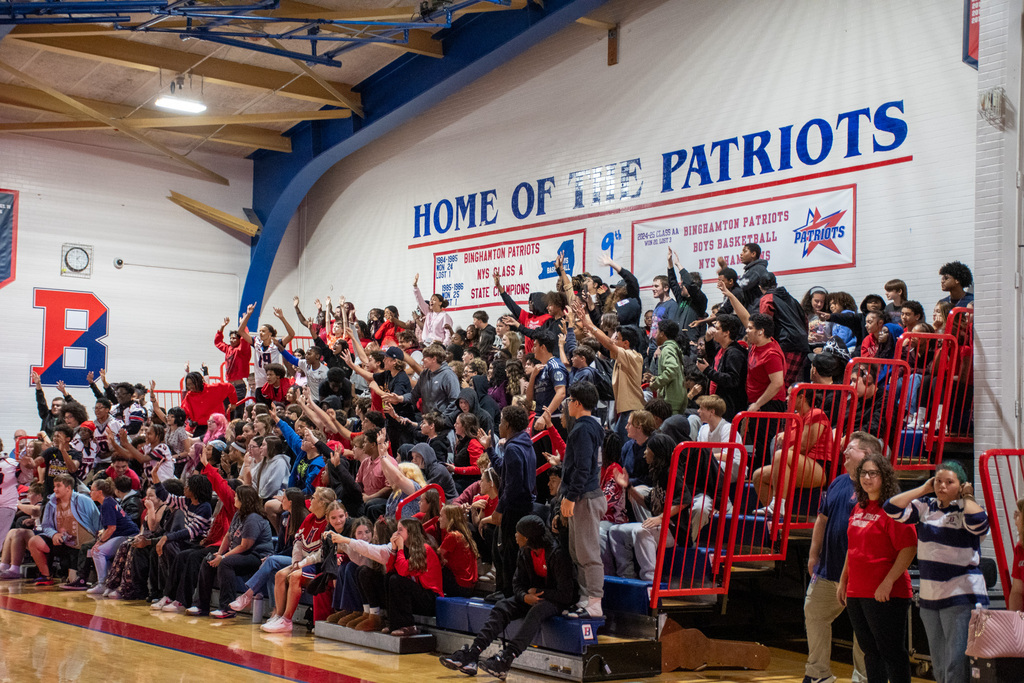 students cheer while sitting in bleachers inside bhs gym