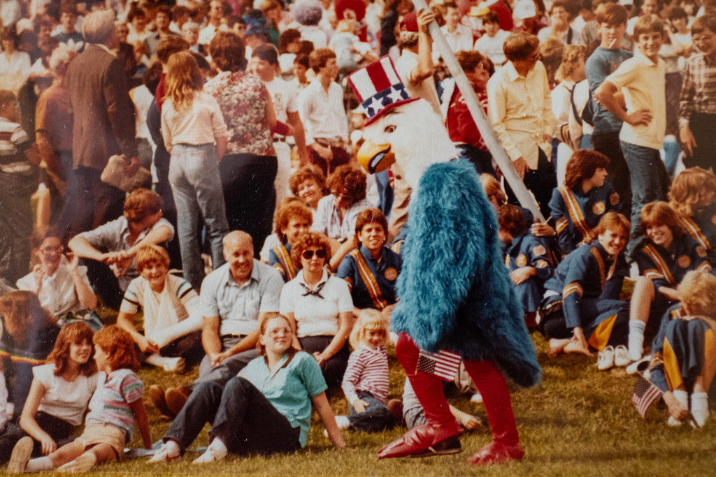 binghamton patriotic eagle mascot walks through crowd holding small american flag