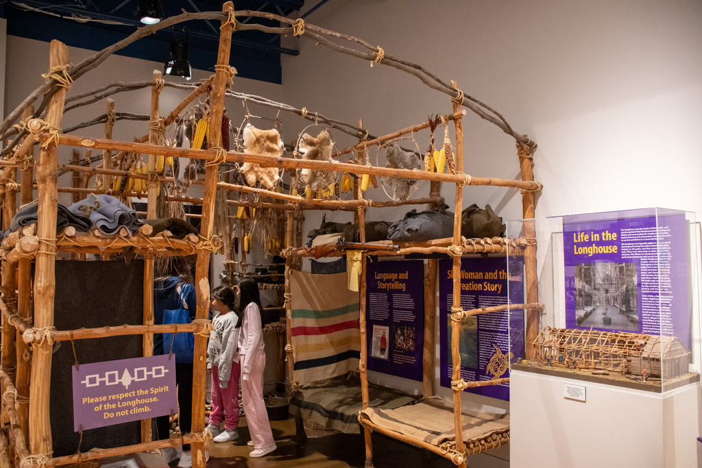 students look inside replica longhouse