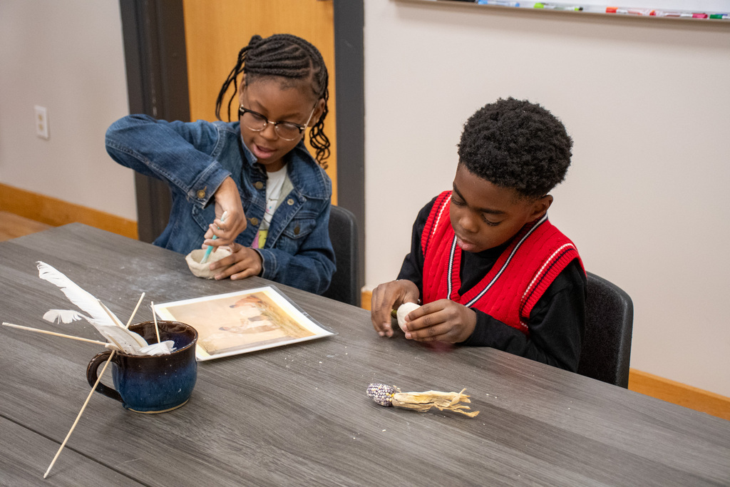 two students make clay pottery