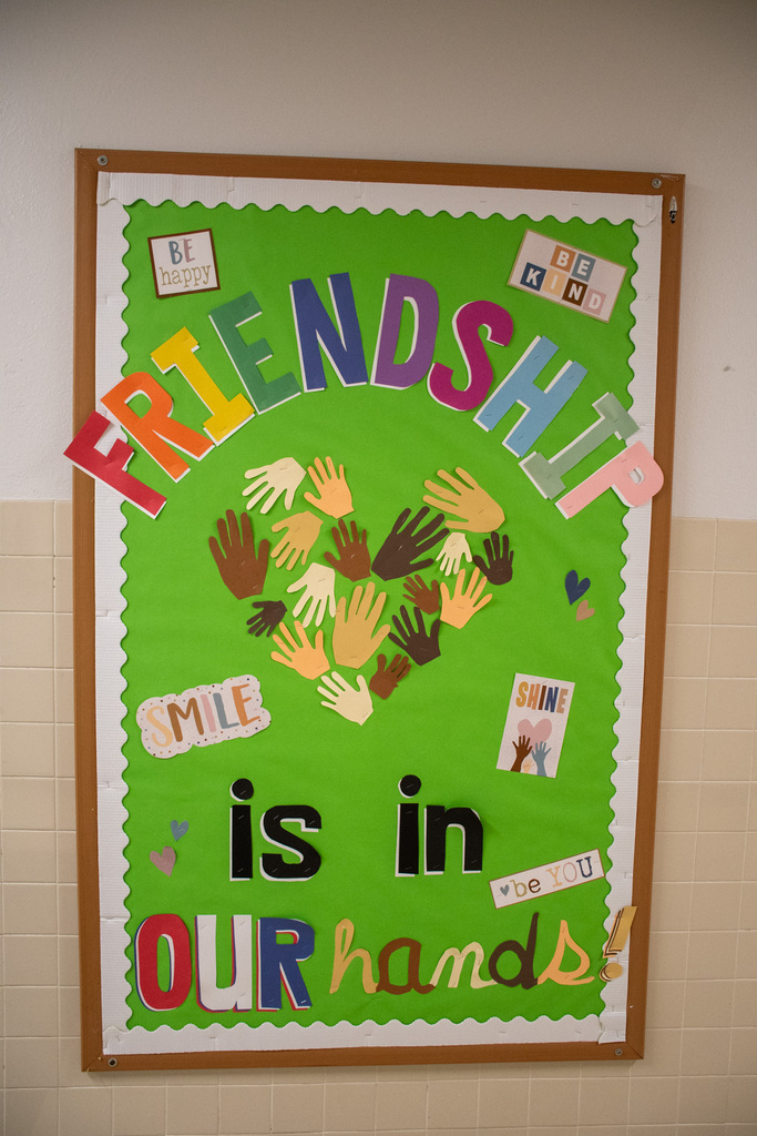 poster in hallway that says "friendship is in our hands" with cut-outs of children's hands making the shape of a heart