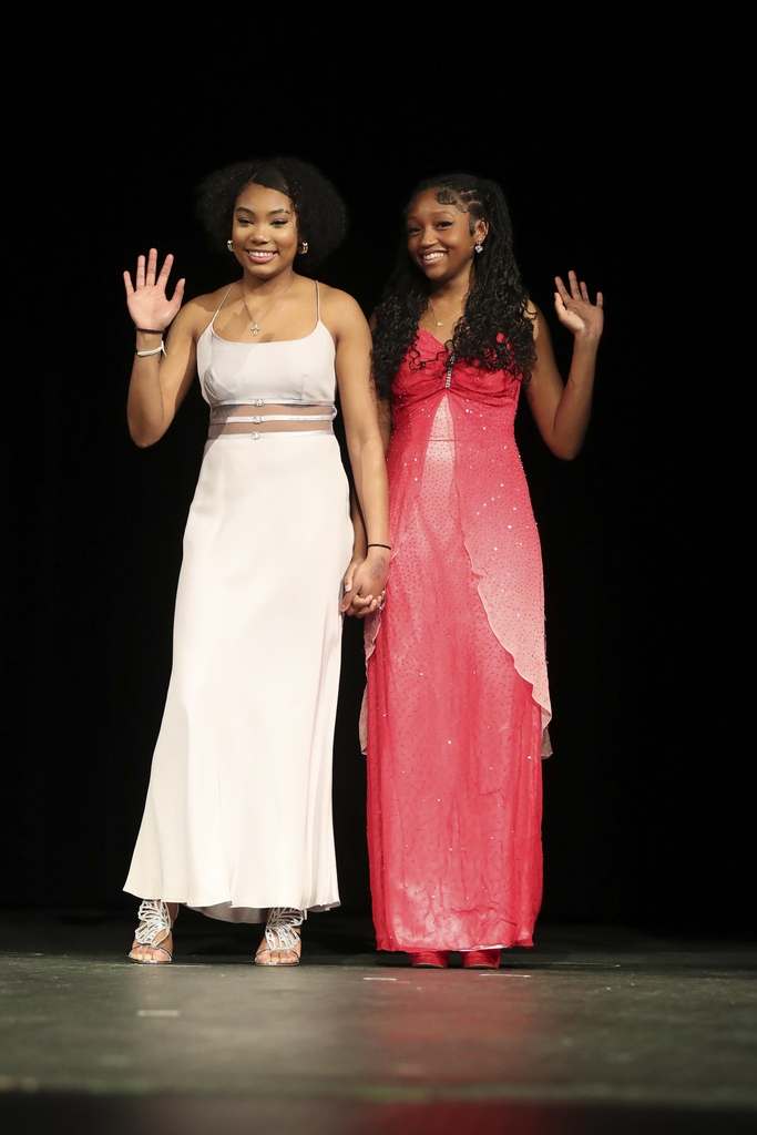 students modeling white and pink prom dresses