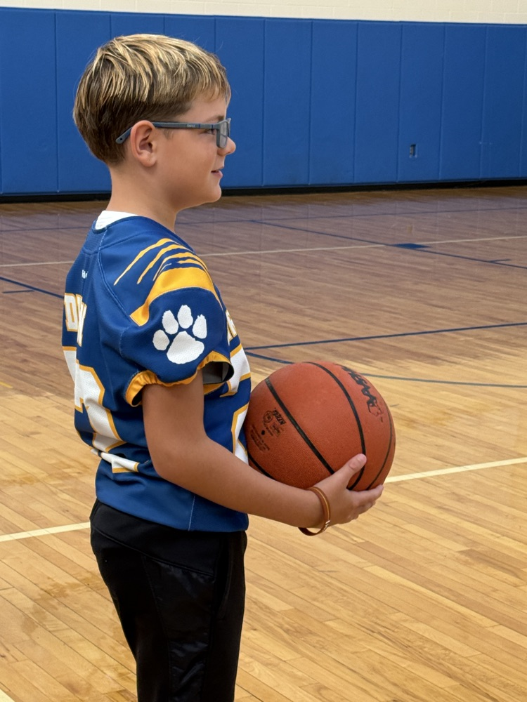 4th graders work on basketball skills in gym 