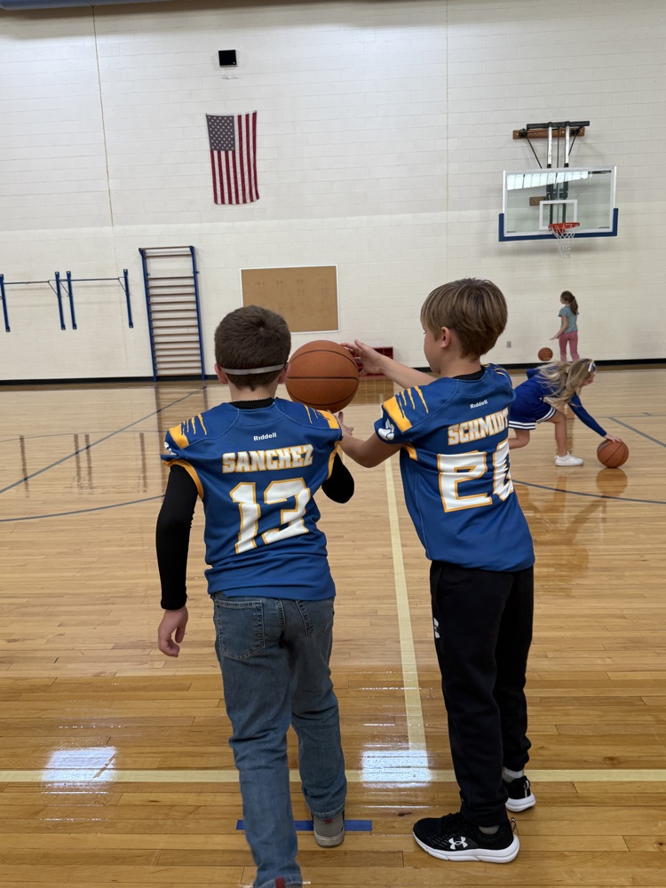 4th graders work on basketball skills in gym 
