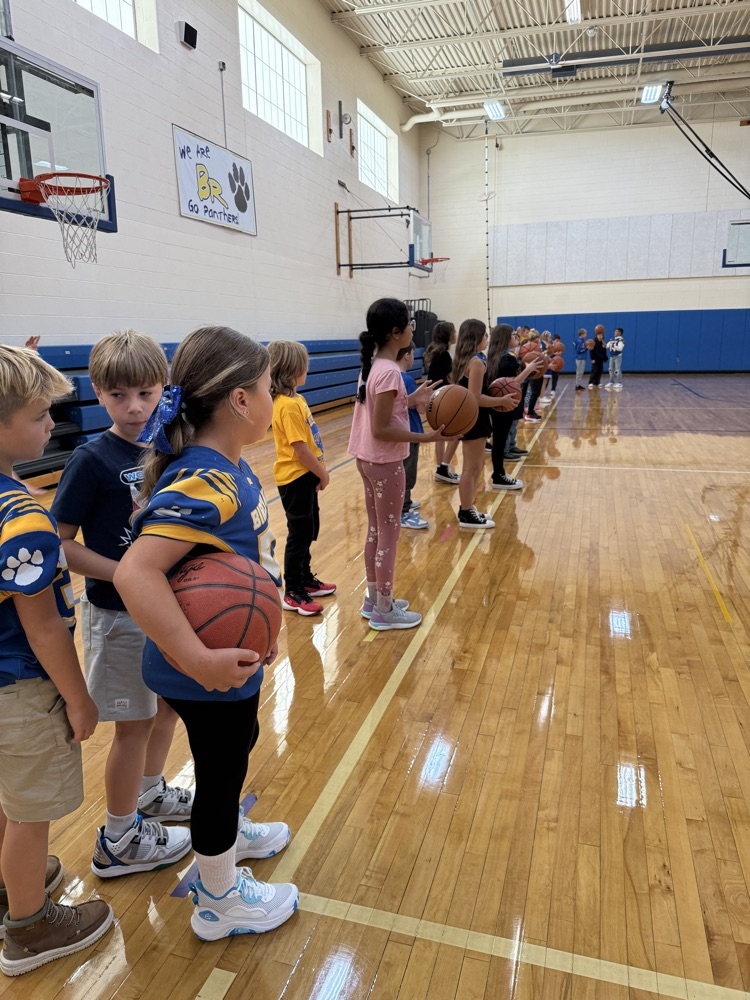 4th graders work on basketball skills in gym 