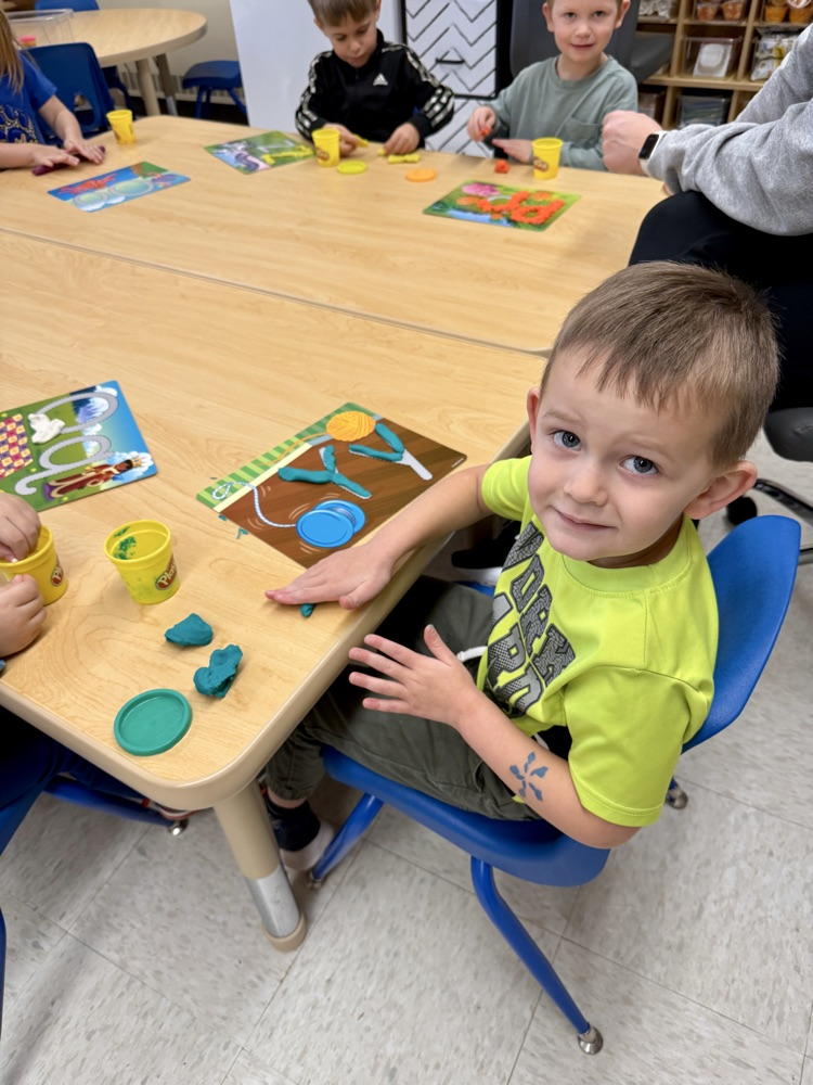 pre-K playing with Play-Doh letter mats